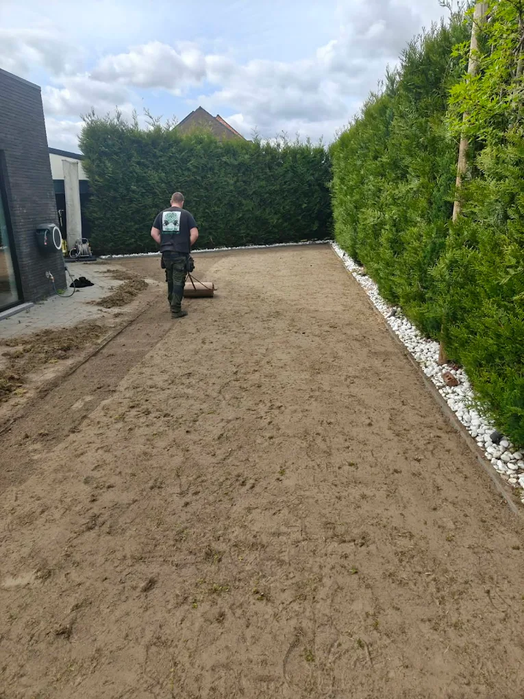 Tuinman aan het werk in een verzorgde tuin in Wichelen